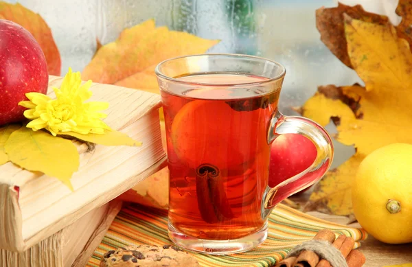 Cup of hot tea and autumn leaves, on wooden table — Stock Photo, Image