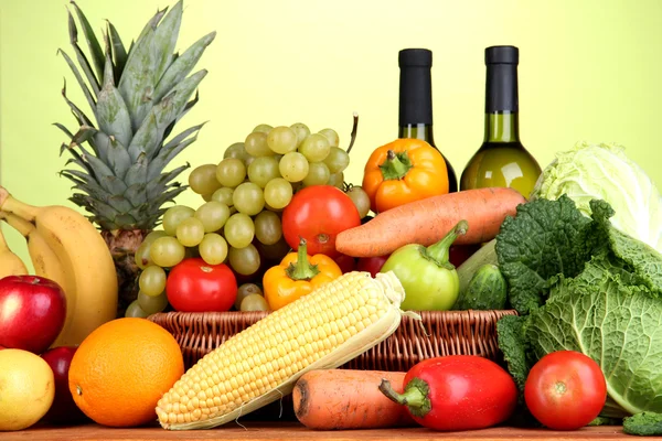 Composição com legumes e frutas em cesta de vime no fundo verde — Fotografia de Stock