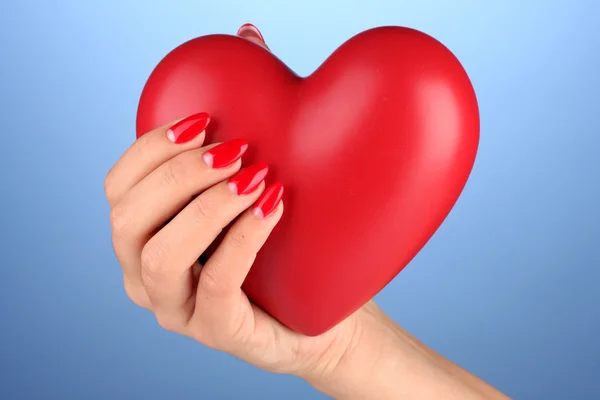 Red heart in woman's hand on color background — Stock Photo, Image