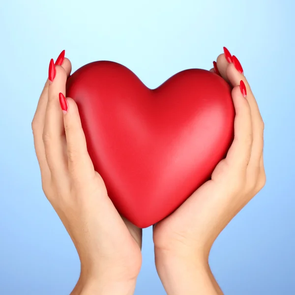 Rood hart in handen van de vrouw op kleur achtergrond — Stockfoto