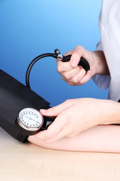 Medición de la presión arterial sobre fondo azul — Foto de Stock