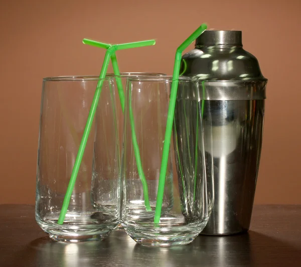 Cocktail shaker and glasses on color background — Stock Photo, Image