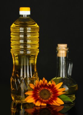 bir plastik şişe ve siyah arka plan üzerine izole küçük sürahi ayçiçek yağı