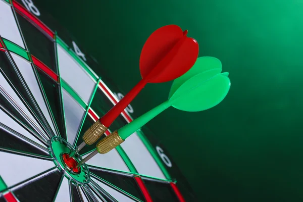 Dart board met darts op groene achtergrond — Stockfoto