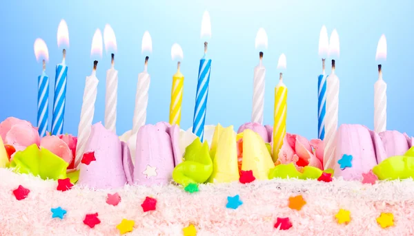 Pastel de cumpleaños con velas sobre fondo azul — Foto de Stock