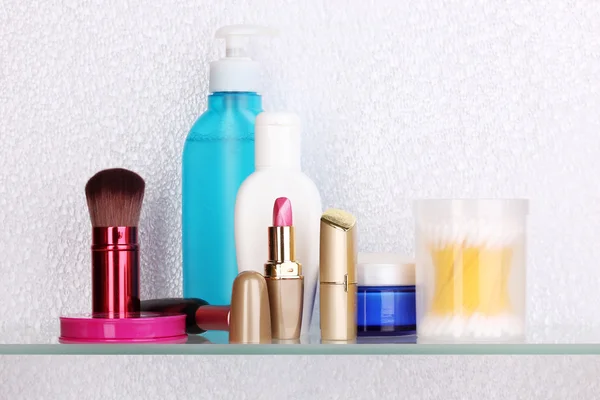 Étagère avec cosmétiques et articles de toilette dans la salle de bains — Photo