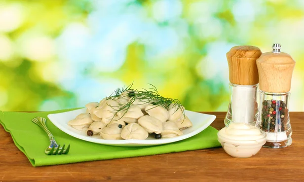 Deliziosi gnocchi cotti nel piatto su sfondo verde brillante — Foto Stock