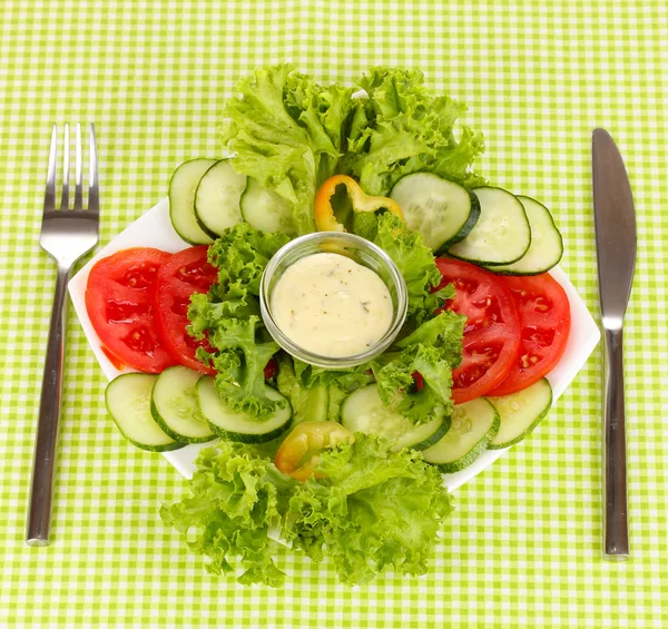 Verduras picadas y salsa en plato sobre mantel verde —  Fotos de Stock