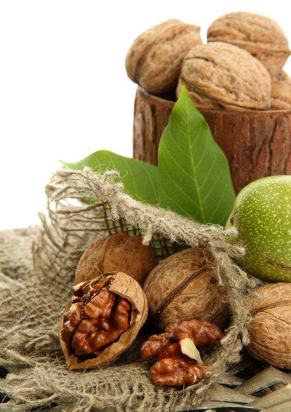 walnuts with green leaves in woooden vase, isolated on white