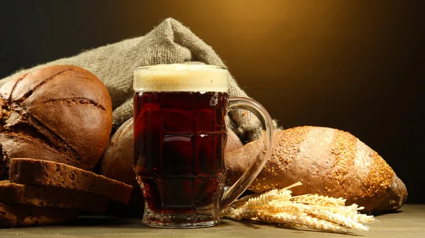 Korbel Kvas a žitné chleby s ušima, na dřevěný stůl na hnědé pozadí — Stock fotografie