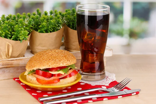 Panino appetitoso su piastra di colore su tavolo in legno su sfondo finestra — Foto Stock