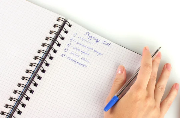 Mão da mulher segurando um caderno com uma lista de compras close-up — Fotografia de Stock