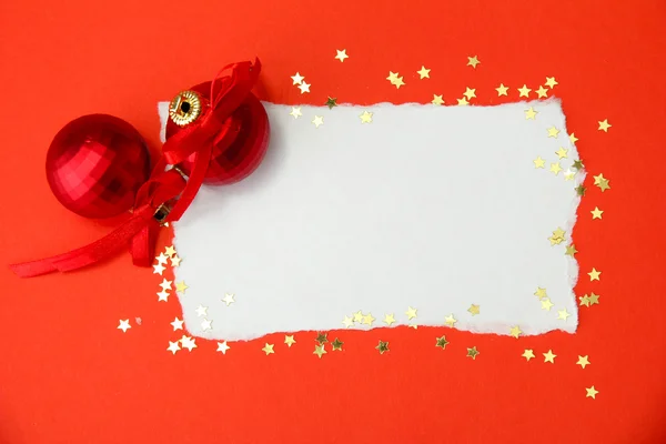 Mooie lichte kerstballen en lege briefkaart op rode achtergrond — Stockfoto