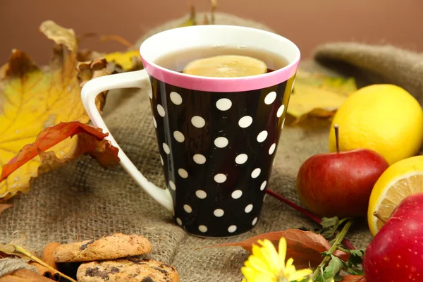 Fincan sıcak çay ve çuval bezi arka planda sonbahar yaprakları — Stok fotoğraf