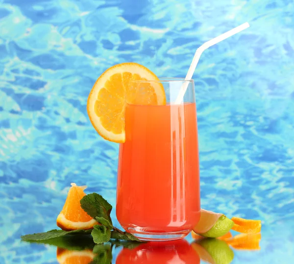 Glass of orange cocktail on blue background — Stock Photo, Image