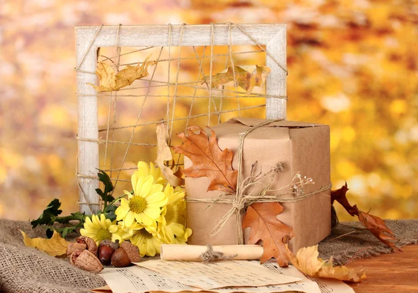 Höstlig sammansättning med gåva, blommor och blad på ljus bakgrund — Stockfoto