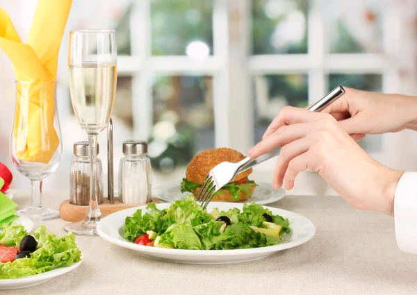 Weibliche Hand mit Abendessen auf hellem Hintergrund — Stockfoto