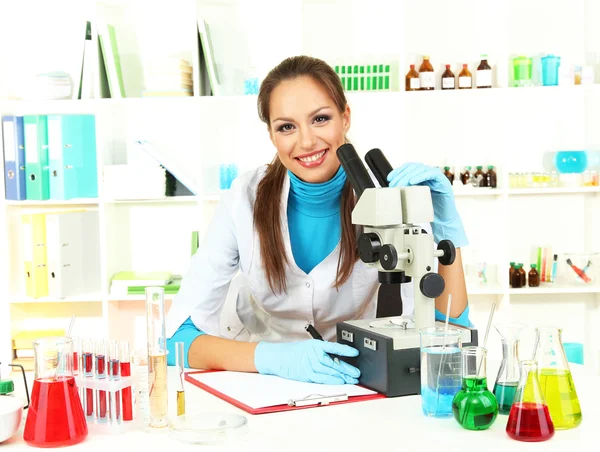 Jovem cientista olhando para o microscópio em laboratório — Fotografia de Stock