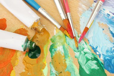 soyut akrilik boya, boya tüpleri ve fırçalar ahşap palet üzerinde