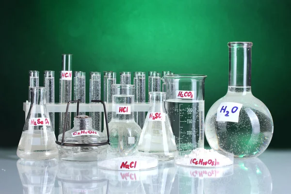 Пробирки с различными кислотами и химикатами на ярком фоне — стоковое фото