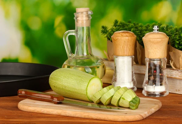 Zucca affettata su un tagliere su tavolo di legno su sfondo verde — Foto Stock