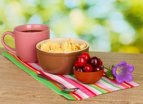 Leckeres Müsli mit Kirschen zum Frühstück auf Holztisch auf grünem Hintergrund — Stockfoto