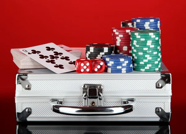 Poker set on a metallic case on bright red background — Stock Photo, Image