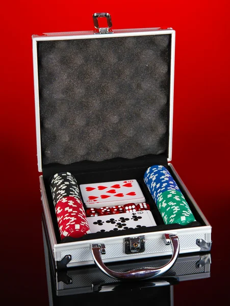 Poker-Set in metallischem Etui auf knallrotem Hintergrund — Stockfoto