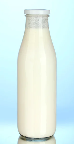 Flasche Milch auf blauem Hintergrund Nahaufnahme — Stockfoto