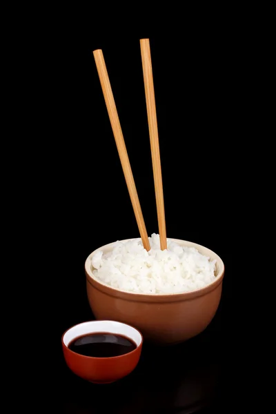 Bowl of rice and chopsticks isoalted on black — Stock Photo, Image