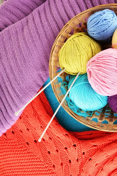 Kolorowe wełniane swetry i kulki z wełny z bliska — Zdjęcie stockowe
