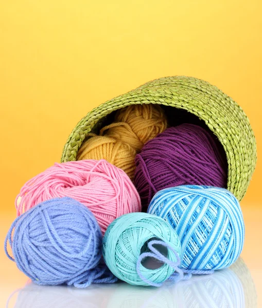 Colorful yarn for knitting in green basket on orange background — Stock Photo, Image