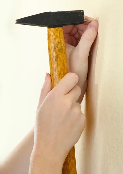 Vrouw handen met nagel en de hamer — Stockfoto