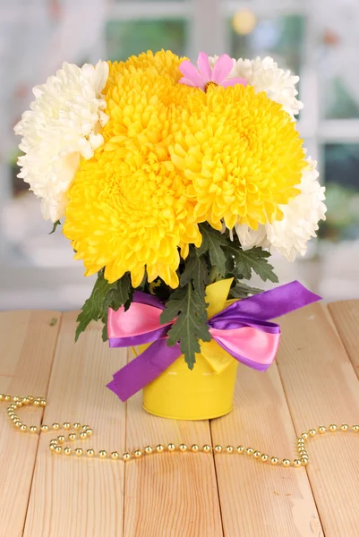 Hermoso crisantemo en cubo sobre mesa de madera sobre fondo de ventana — Foto de Stock
