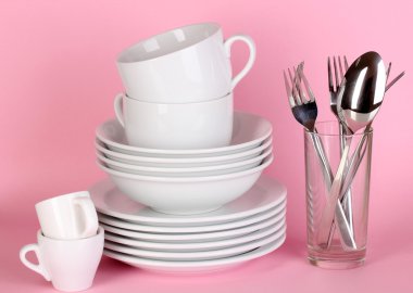 pembe bir arka plan üzerinde beyaz bulaşıkları temizle