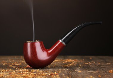 boru ve siyah arka plan üzerine ahşap masa üzerinde tütün Sigara
