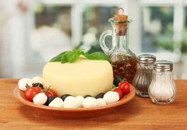 Fromage mozzarella avec légumes dans l'assiette sur table en bois close-up — Photo