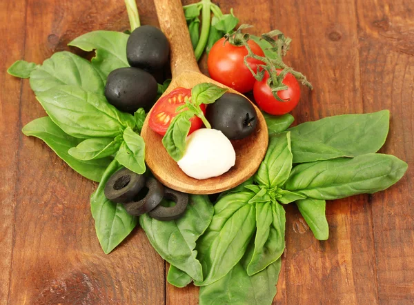 Mozzarella di formaggio con verdure in cucchiaio di legno su fondo di legno primo piano — Foto Stock