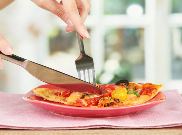 Női kéz vágni egy szelet pizza közelről — Stock Fotó