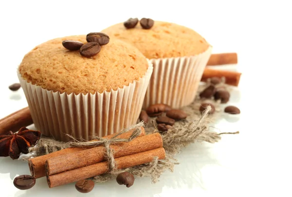 Tasty muffin cakes on burlap, spices and coffee seeds, isolated on white — Zdjęcie stockowe