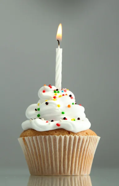 Sabroso cupcake de cumpleaños con vela, sobre fondo gris —  Fotos de Stock