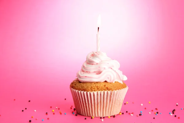 Cupcake de aniversário saboroso com vela, no fundo rosa — Fotografia de Stock