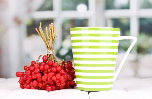 Tea with red viburnum on table on bright background — Stock Photo, Image