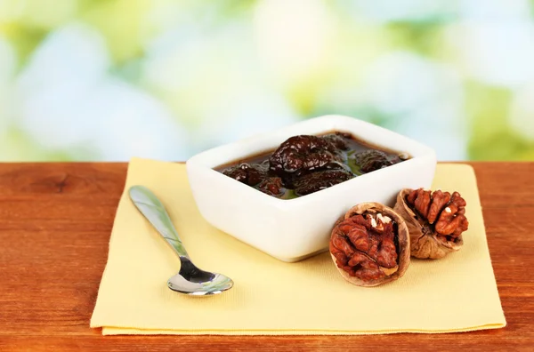 Jam walnoten in een kom op een tafel op een groene achtergrond — Stockfoto