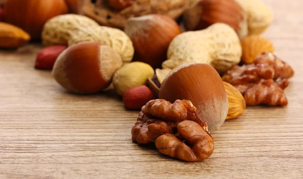 Sortiment av välsmakande nötter på trä bakgrund — Stockfoto