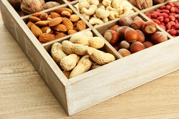 Assortment of tasty nuts in wooden box — Stock Photo, Image