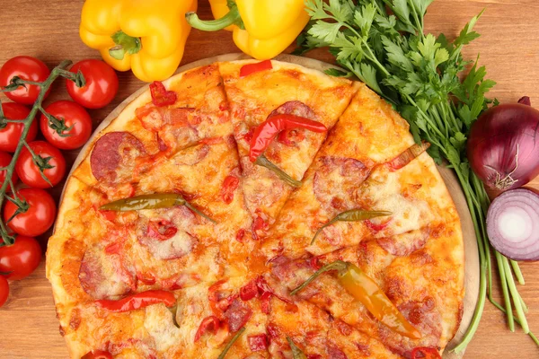 Ízletes pepperoni pizza zöldségekkel, fából készült táblán a fából készült háttér — Stock Fotó