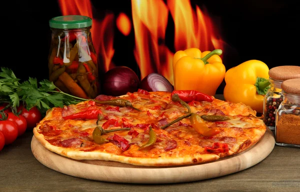 Maukas pepperoni pizza vihanneksia puulaudalla liekki tausta — kuvapankkivalokuva