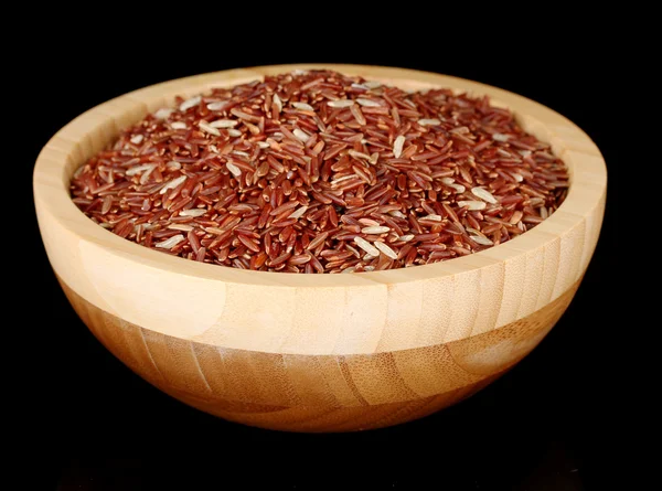 Ahşap kase üzerine siyah izole kırmızı pirinç — Stok fotoğraf