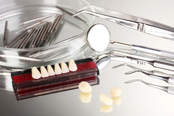 Set of dental tools with denture on grey background — Stock Photo, Image